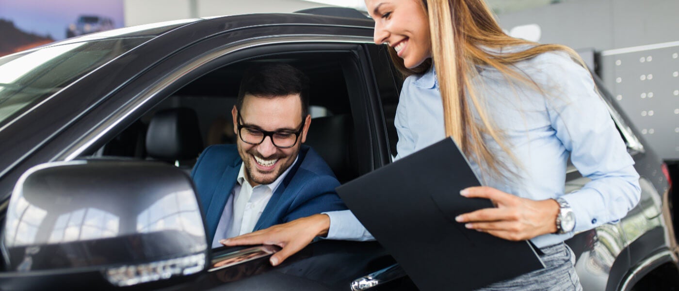 Saleswoman and customer speaking in car