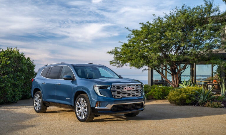 2026 GMC Acadia parked by glass seaside house