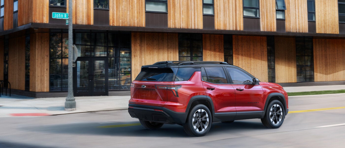 2027 Chevy Equinox driving past wooden building