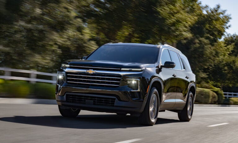 2027 Chevy Traverse driving past fence